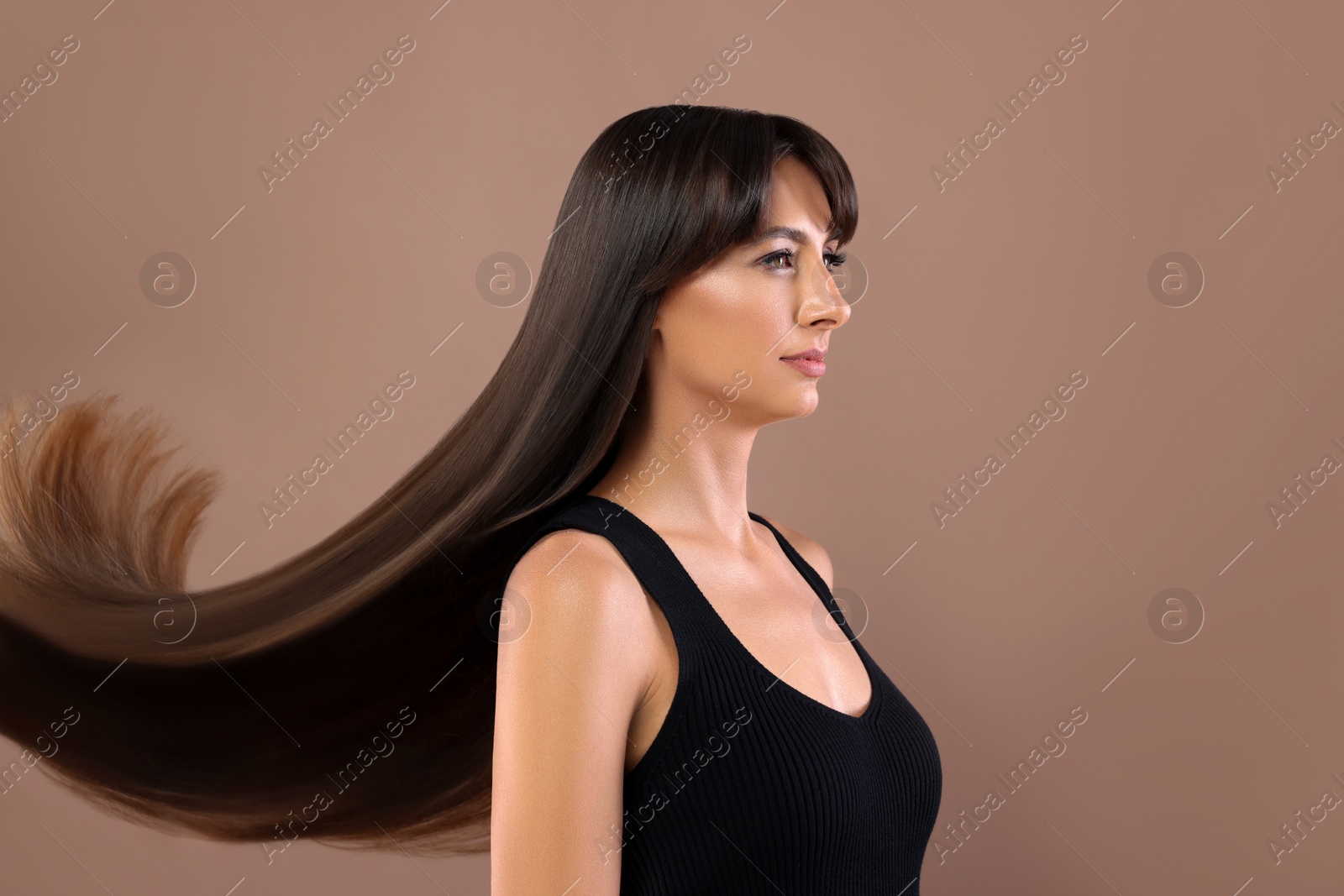 Image of Hair styling. Attractive woman with straight long hair on pale brown background