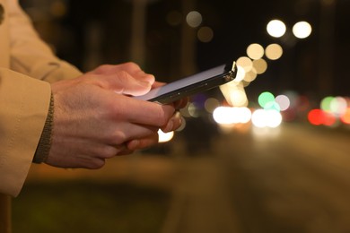 Photo of Man using smartphone on night city street, closeup. Space for text