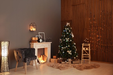 Photo of Stylish room interior with Christmas tree and decorative fireplace