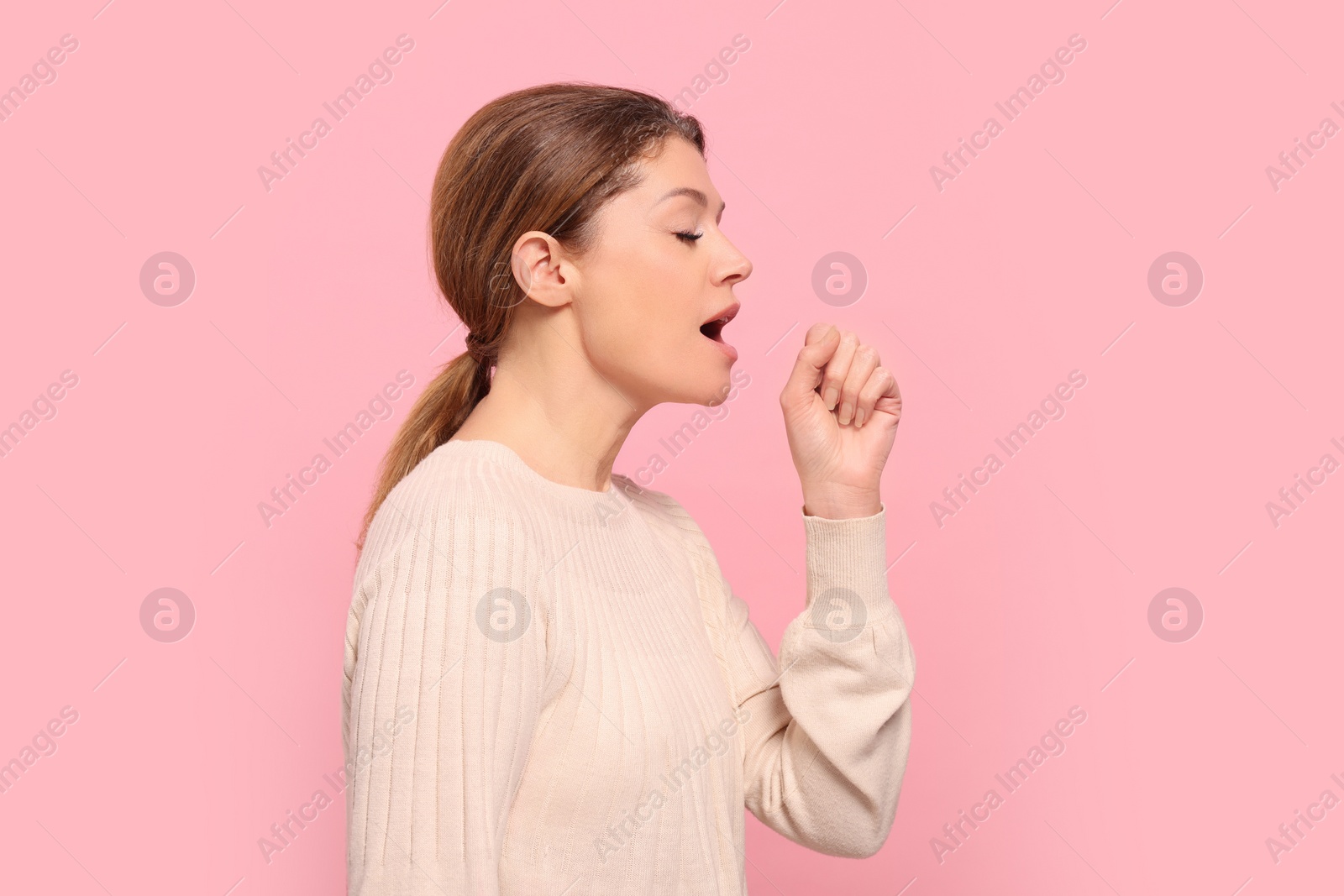 Photo of Woman coughing on pink background. Sore throat