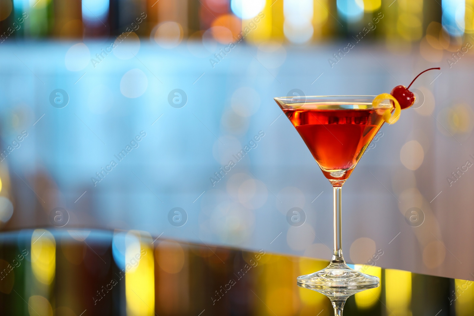 Photo of Glass of fresh alcoholic cocktail on bar counter. Space for text