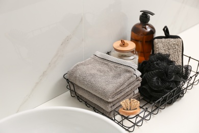 Personal hygiene products on table near white wall in bathroom