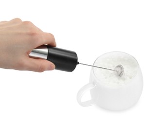 Woman whisking milk in cup with mini mixer (frother wand) isolated on white