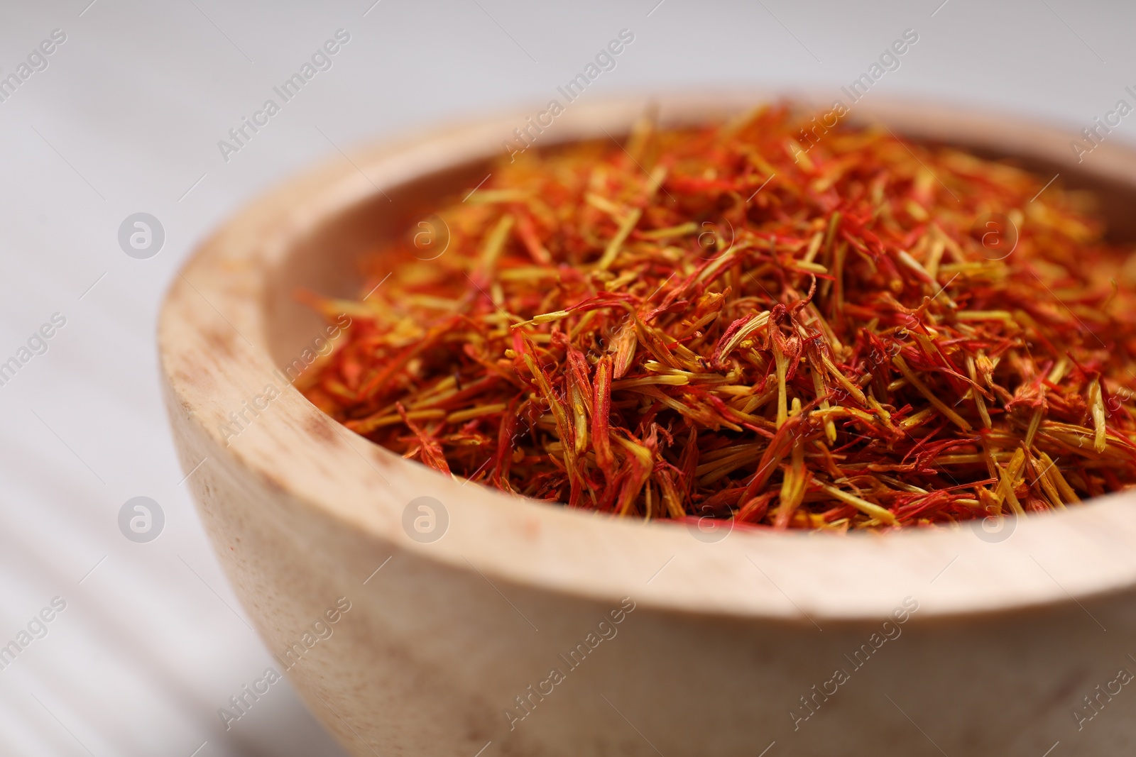 Photo of Aromatic saffron in bowl on table, closeup