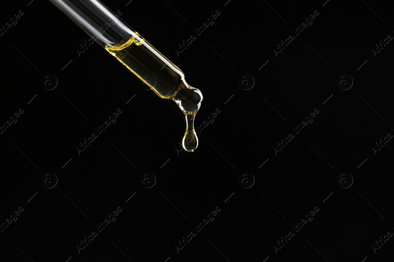 Photo of Dripping tincture from pipette on black background, closeup. Space for text