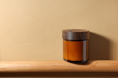 Photo of Jar of luxury cream on dark beige background. Space for text