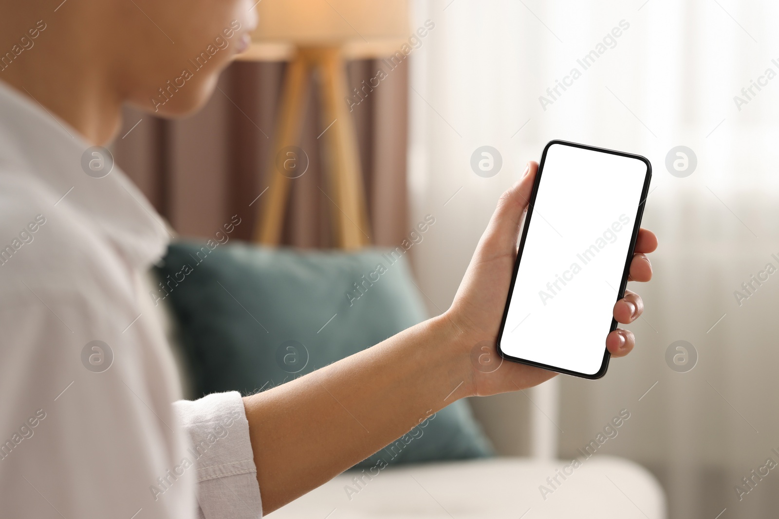 Photo of Man using smartphone with blank screen indoors, closeup. Mockup for design