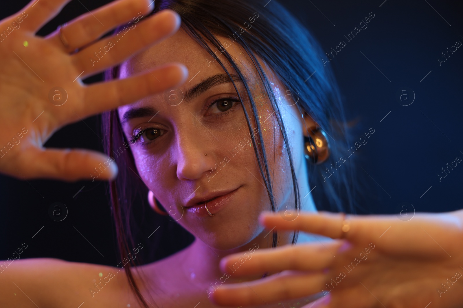 Photo of Portrait of beautiful woman on dark background in neon lights