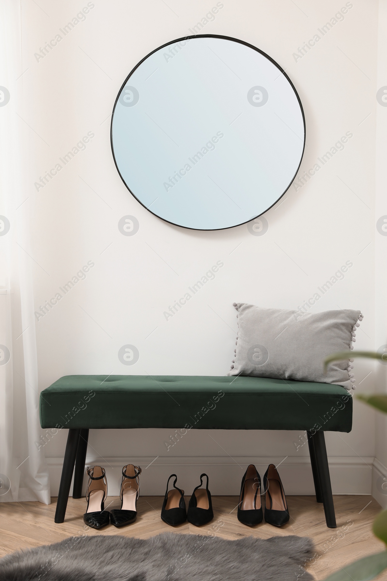 Photo of Green bench, mirror and women's shoes indoors. Interior design