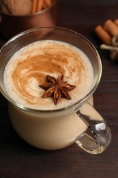 Delicious eggnog with spices on wooden table, above view