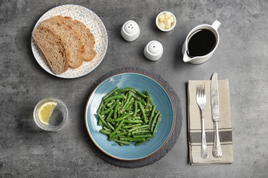 Photo of Flat lay composition with plate of fresh green bean salad on table