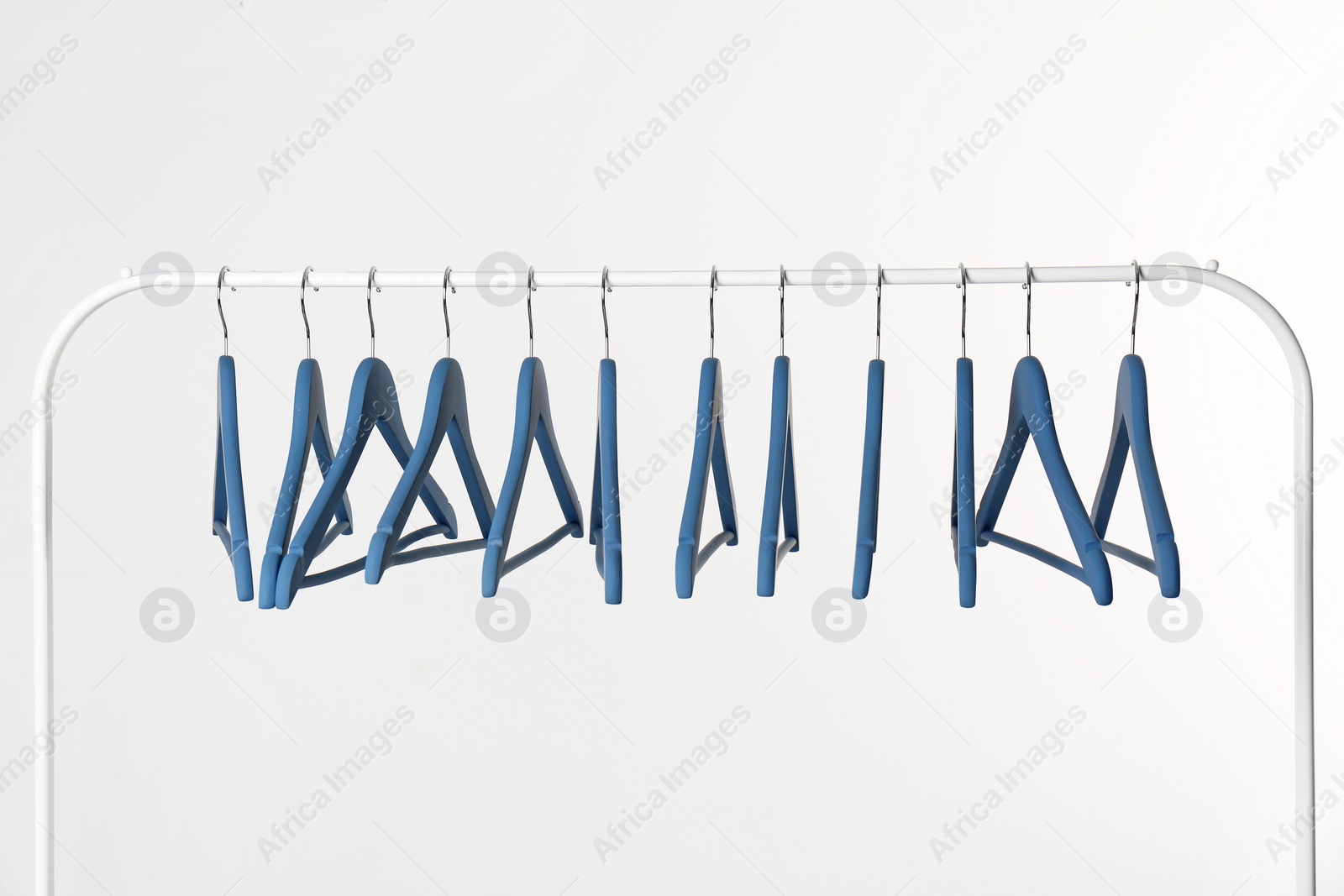 Photo of Metal rack with clothes hangers on white background