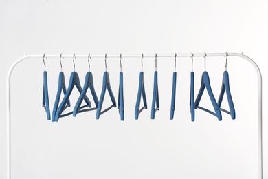 Photo of Metal rack with clothes hangers on white background