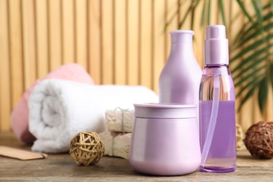 Photo of Set of hair care cosmetic products on wooden table