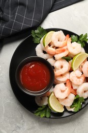 Tasty boiled shrimps with cocktail sauce, parsley and lime on light grey table, top view