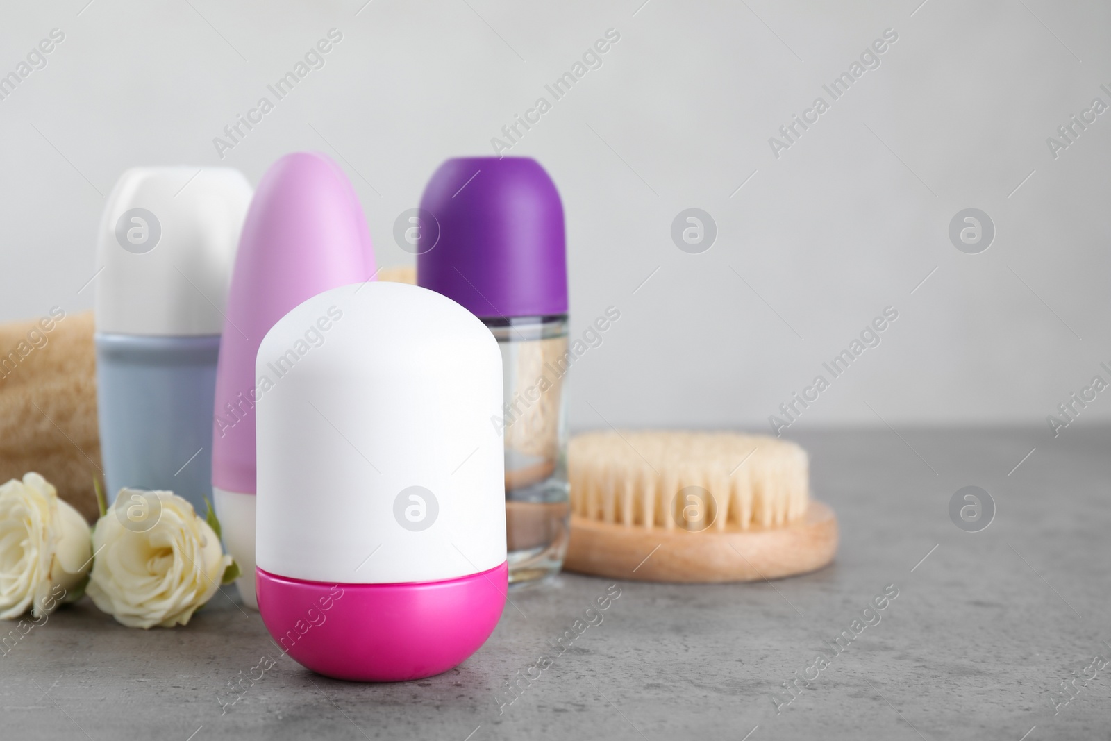 Photo of Composition with natural roll-on deodorants on grey marble table. Space for text