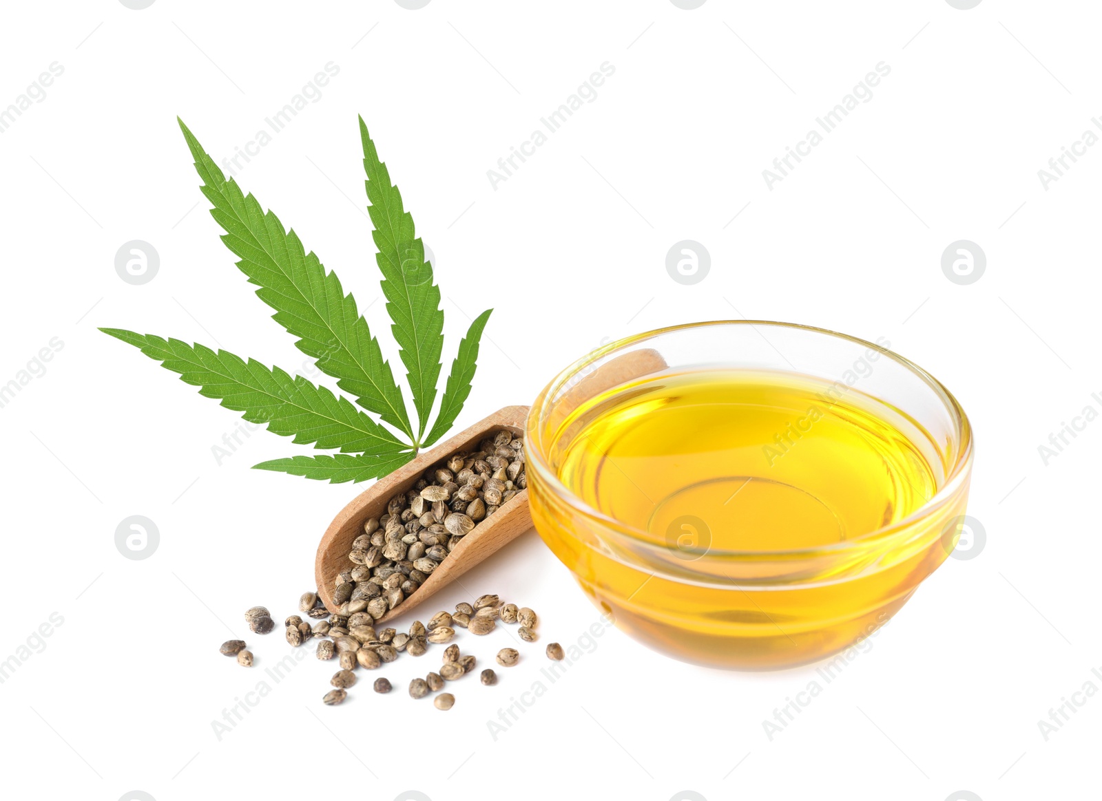 Photo of Bowl of hemp oil, fresh leaf and seeds on white background