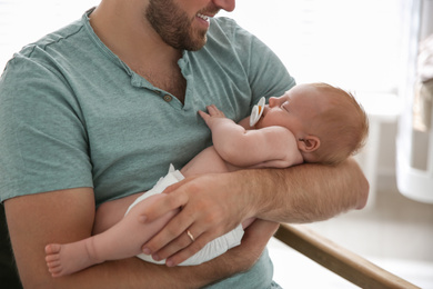 Father with his newborn son at home, closeup