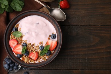 Photo of Bowl with yogurt, berries and granola on wooden table, flat lay. Space for text