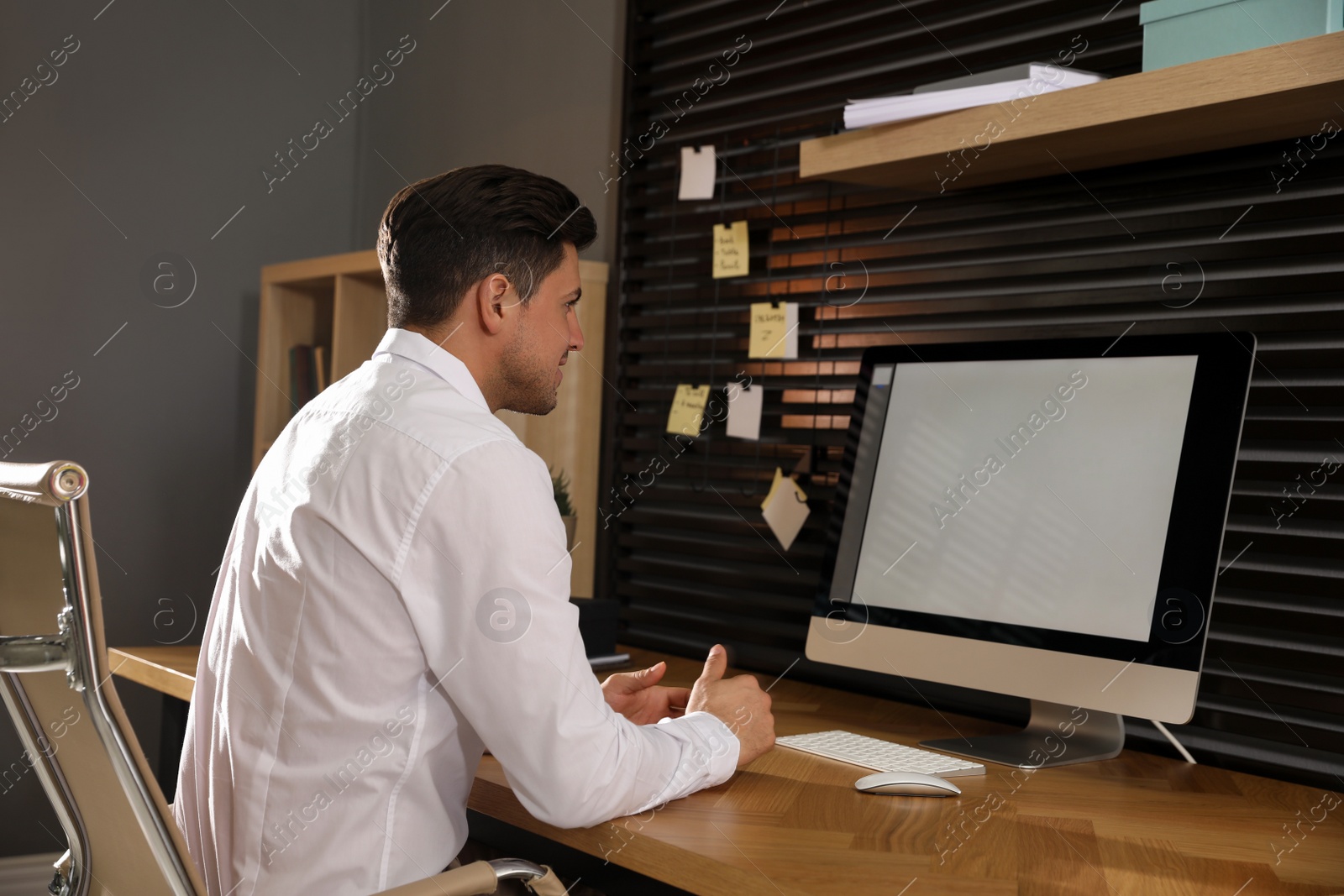 Photo of Man sitting at comfortable workplace with modern computer