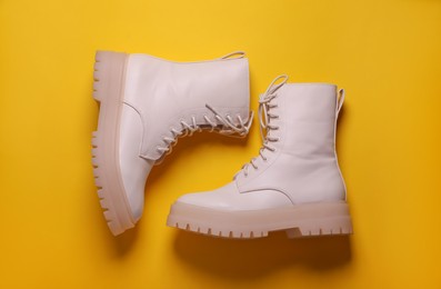 Photo of Pair of stylish shoes on yellow background, flat lay