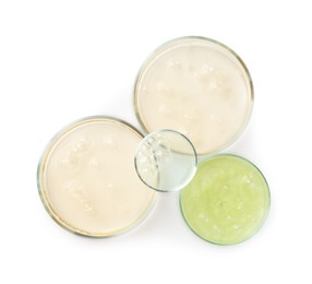 Petri dishes with different liquid samples on white background, top view