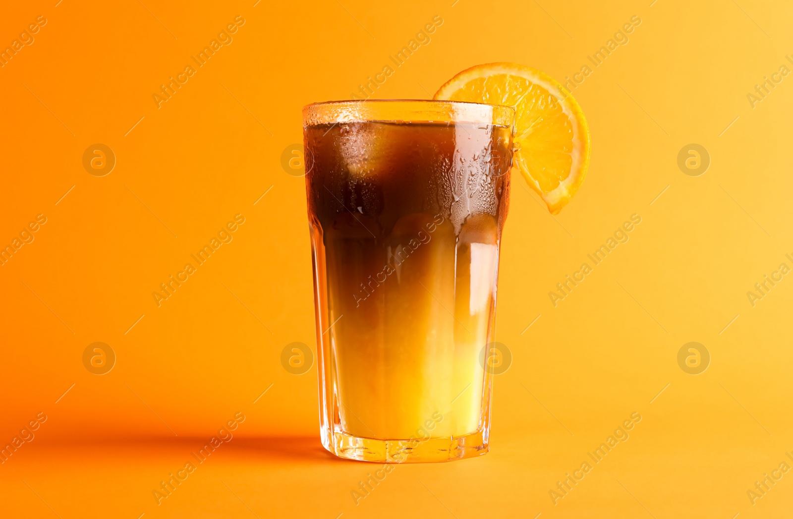 Photo of Tasty refreshing drink with coffee and orange juice on bright color background