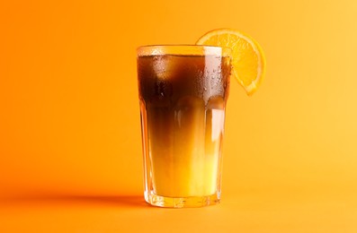 Photo of Tasty refreshing drink with coffee and orange juice on bright color background