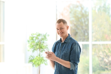 Photo of Portrait of handsome man with mobile phone, indoors