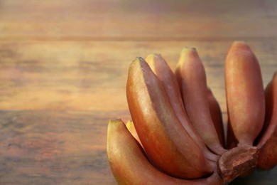 Tasty purple bananas on wooden table, closeup. Space for text