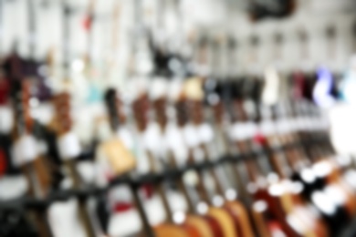 Photo of Blurred view of different guitars in music store