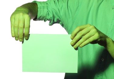 Photo of Man holding sheet of paper on white background, closeup and space for text. Color tone effect