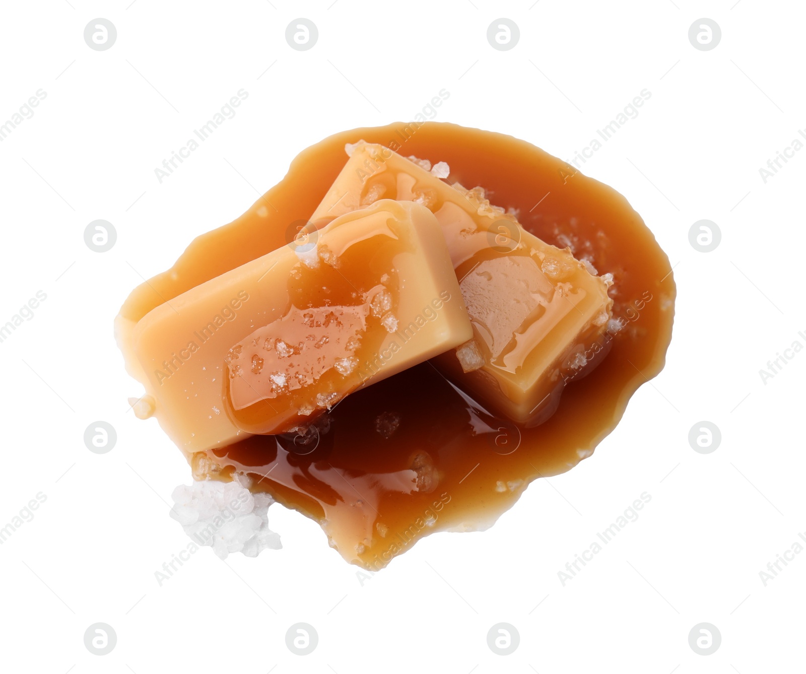 Photo of Yummy caramel candies and sea salt isolated on white, top view