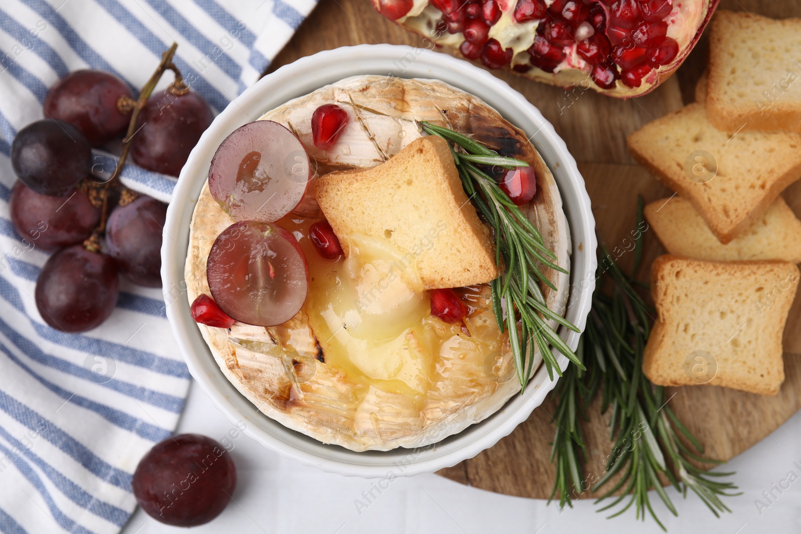 Photo of Flat lay composition with tasty baked camembert on white tiled table