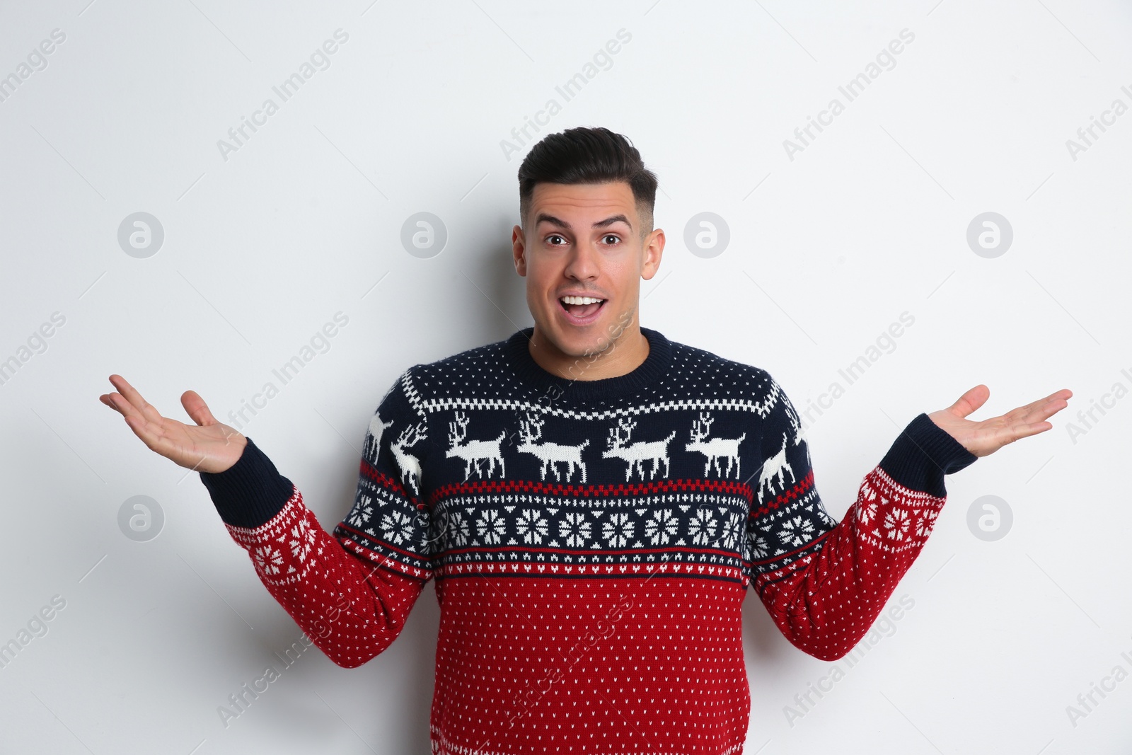 Photo of Surprised man in Christmas sweater on white background
