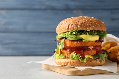 Vegan burger with carrot patties served on table against color background. Space for text