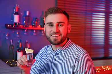 Young man with Mexican Tequila shot in bar