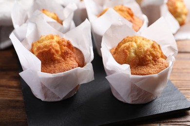 Photo of Delicious sweet muffins on wooden table, closeup