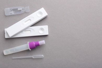 Disposable express test kits on grey background, flat lay. Space for text