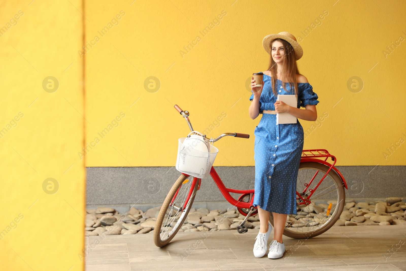 Photo of Woman with modern color bicycle near wall outside. Space for text