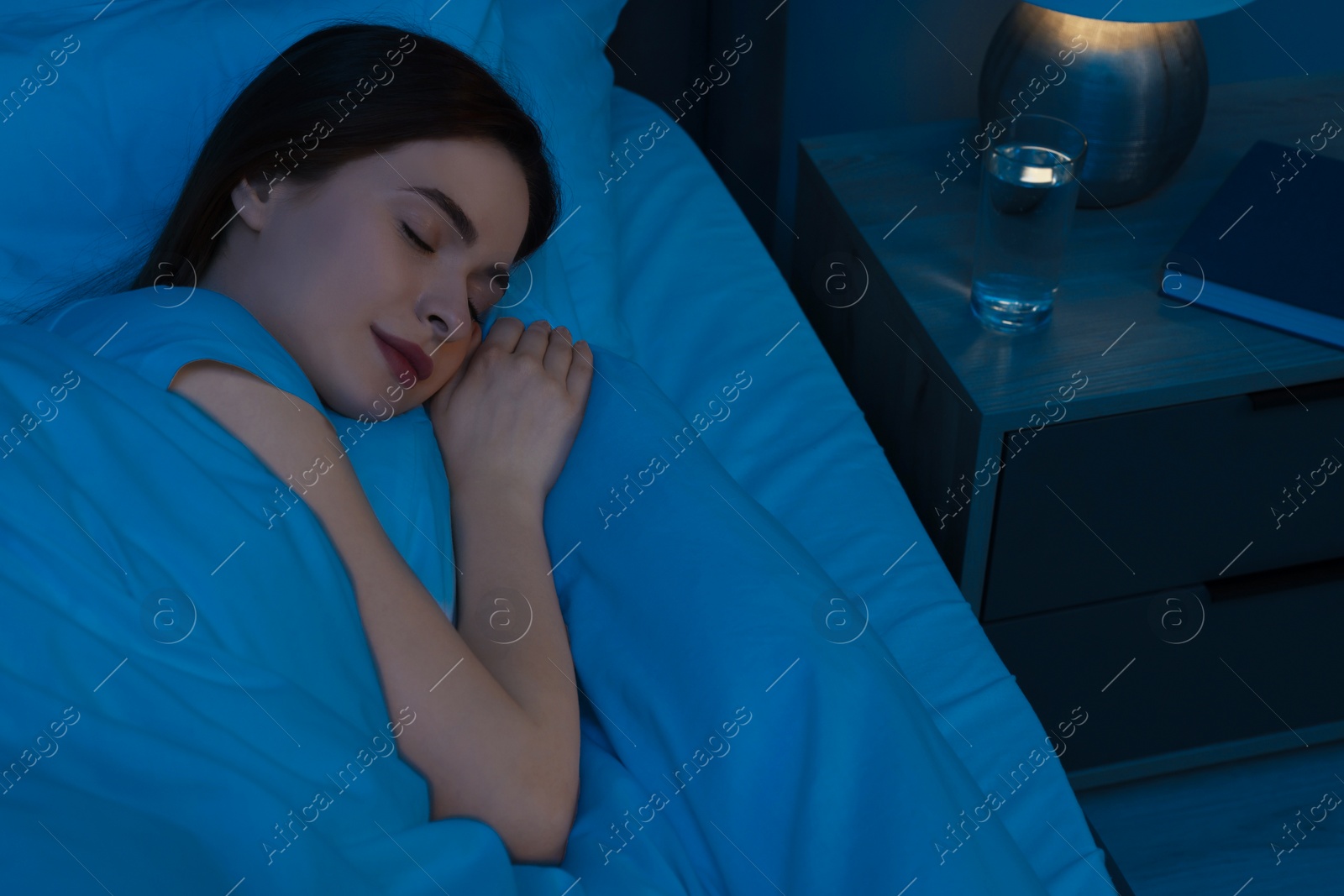 Photo of Beautiful young woman sleeping in bed at night