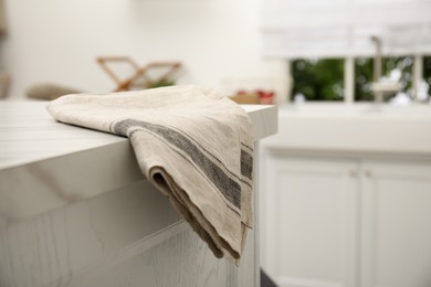 Photo of Clean towel on white marble table in kitchen. Space for text
