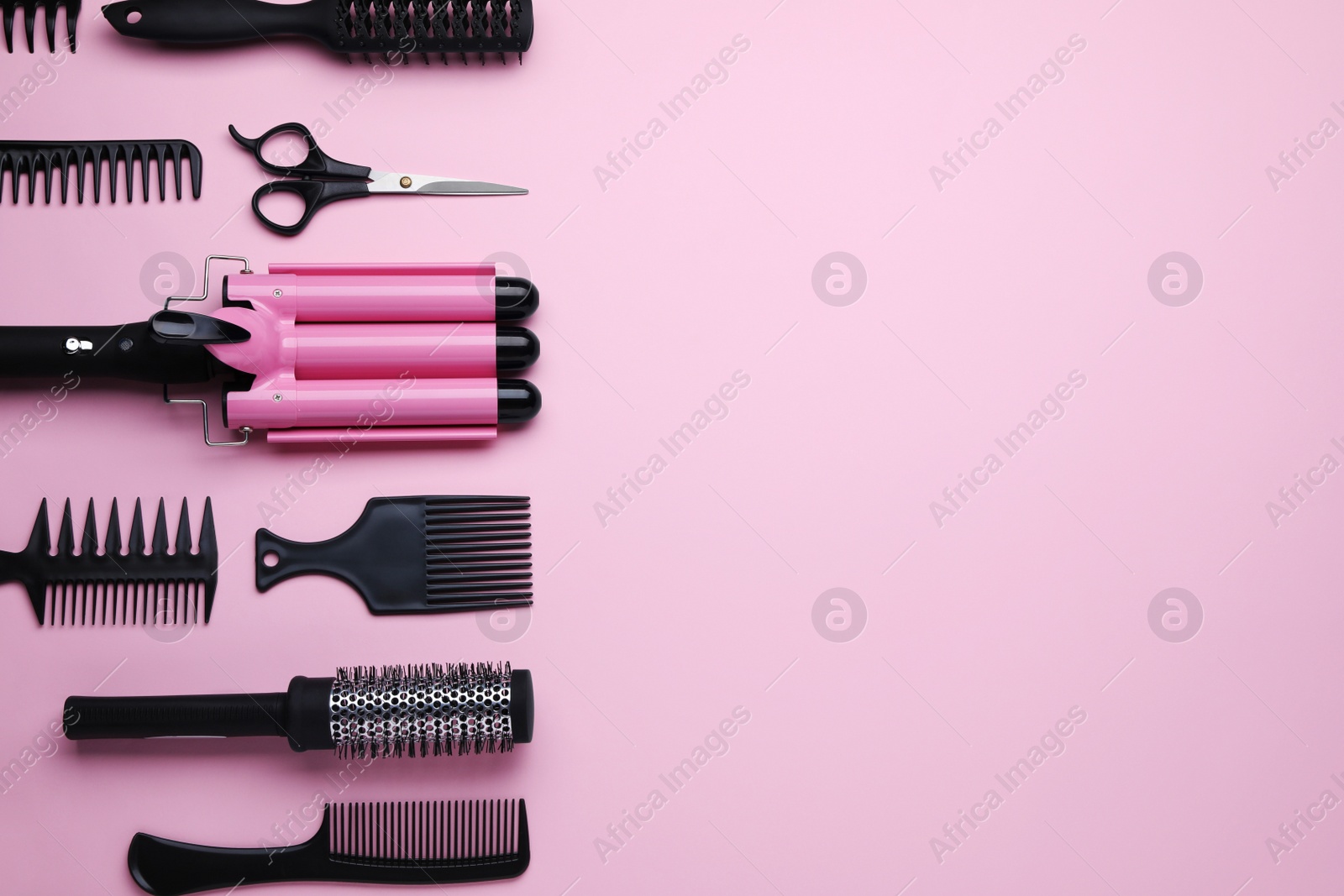 Photo of Flat lay composition with modern hair triple curling iron on pink background, space for text