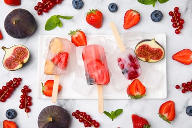 Photo of Flat lay composition with fruit and berry ice pops on light table