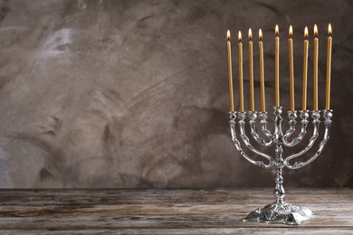 Photo of Hanukkah menorah on table against grey background