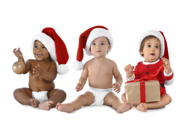 Collage with photos of cute babies wearing Santa hats on white background