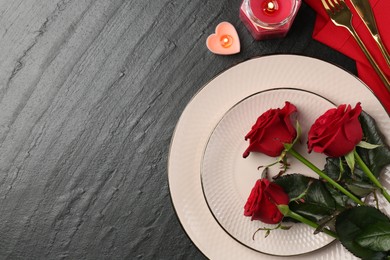 Place setting with candles and roses for romantic dinner on grey textured table, flat lay. Space for text