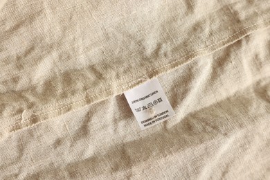 Photo of Clothing label on beige garment, closeup view