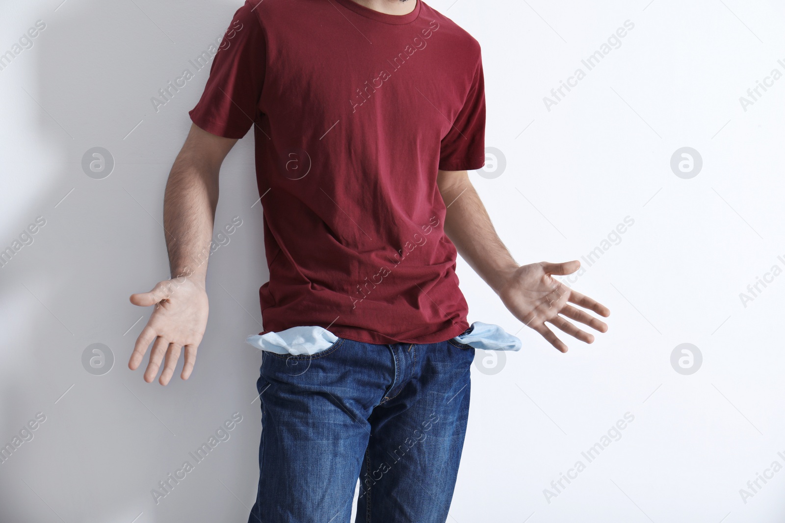 Photo of Man showing empty pockets on light background, closeup