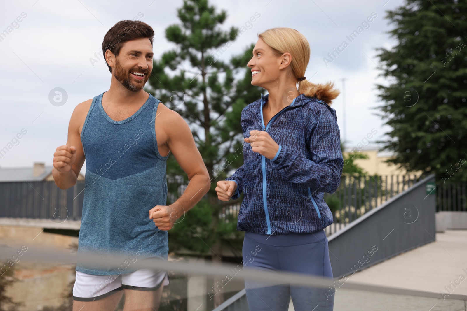 Photo of Healthy lifestyle. Happy sporty couple running outdoors